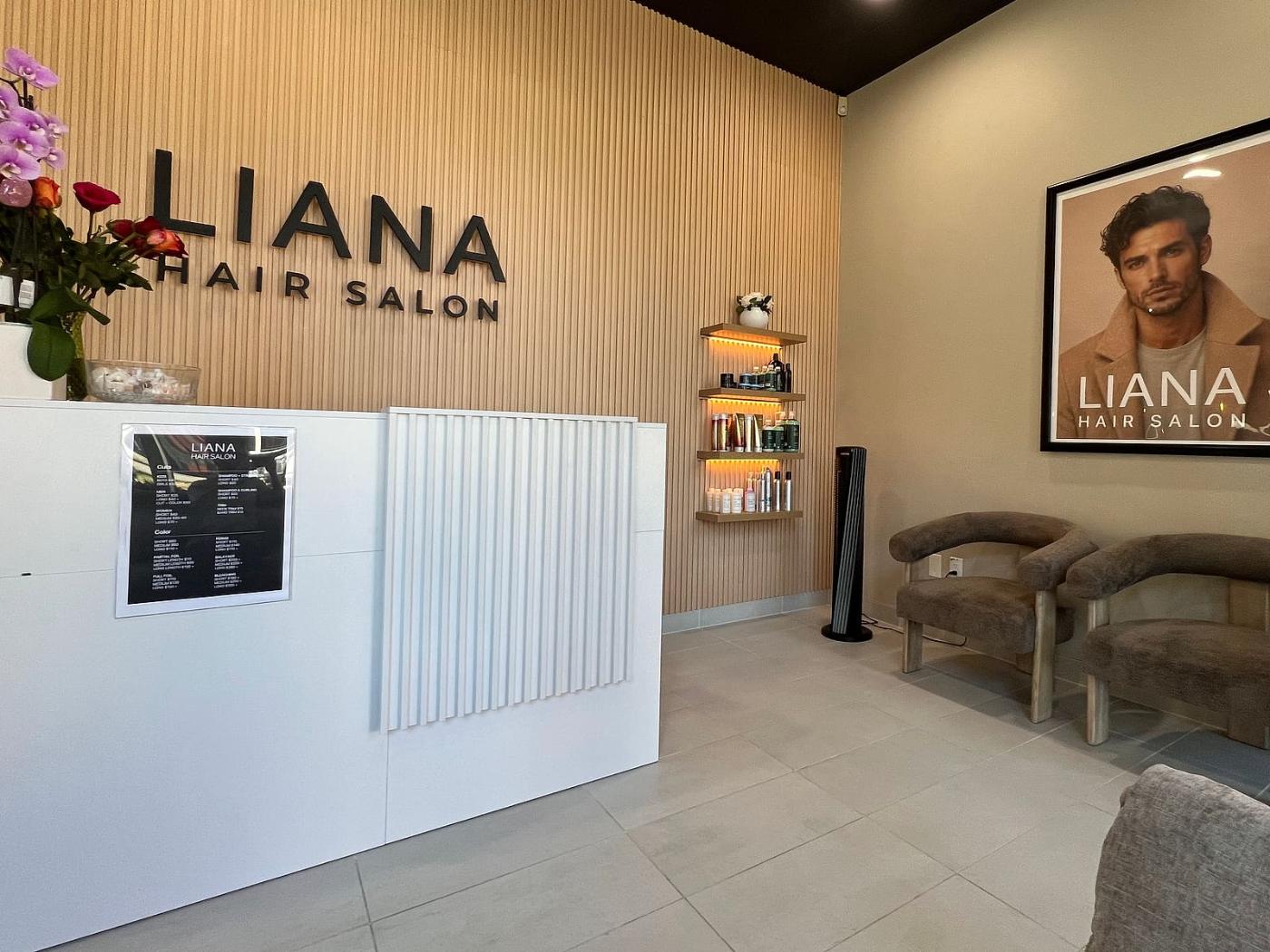 Reception desk and Liana Hair Salon sign on the fluted wood wall in Seattle